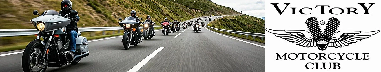 a long line of Victory motorcycles riding down a hill on a mountain road.