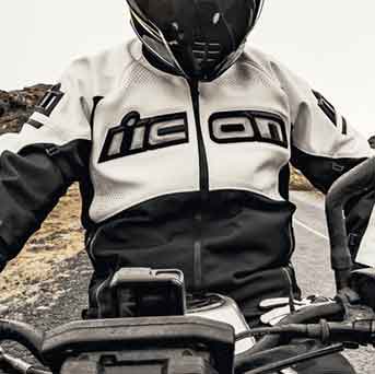 man on a motorcycle wearing a white and black Icon jacket