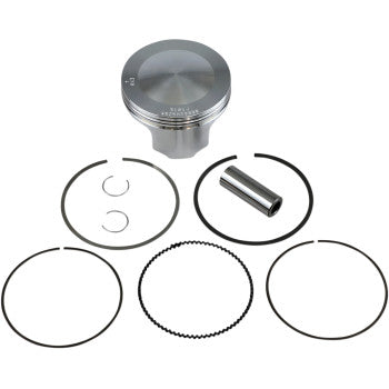 Polished silver piston with wrist pin, circlips, and five black piston rings arranged on white background.