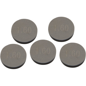 A loose cluster of five round, flat gray metal discs—Prox Valve Shim 9.48 mm x 1.60 mm (5 pack)—each precision machined and engraved with "1.60" on its surface.