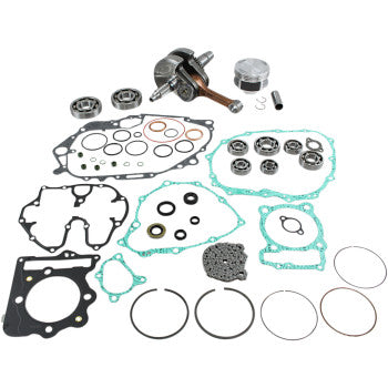 Assorted metal engine parts including crankshaft, bearings, pistons, gaskets, and seals arranged on white background.