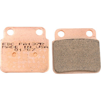 Two SV Severe Duty Brake Pads by EBC are shown side by side—one with printed text, the other displaying its friction material. Each rectangular pad has two top holes and is engineered for utility use, delivering ultra-long life.