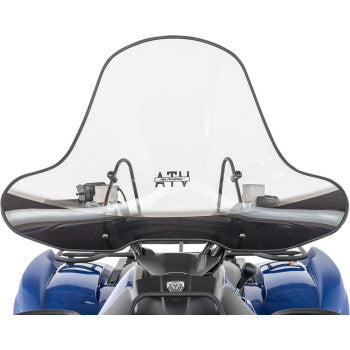 The Big Country Windshield Xtreme by Slipstreamer, a clear polycarbonate ATV windshield with quick-release mounting, is installed on a blue all-terrain vehicle, showing the front view with handlebars and control panel behind it.