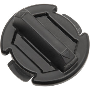 Black round plastic floor drain plug with raised central handle and four notched edges.