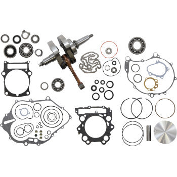 Complete engine rebuild kit with crankshaft, gaskets, seals, bearings, piston, rings, and small metal engine parts laid out.
