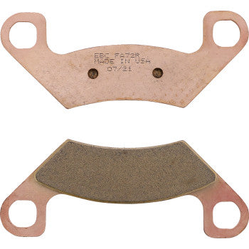 Copper-colored metal brake pads with dark friction surface and two circular holes on each side.
