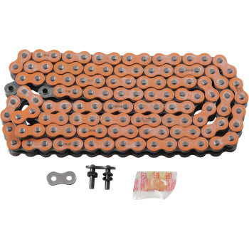 The 525 Max X Drive Chain 120 Links Orange by RK, a Japanese-made orange and silver metal O-ring chain, is coiled on a white background with two connecting pins, a master link, and a small packet of lubricant.