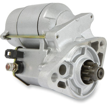 The Starter Motor by Parts Unlimited is a silver, cylindrical automotive starter with visible gear, copper bushings, electrical terminals, and mounting points, designed to OEM specs and shown on a white background.