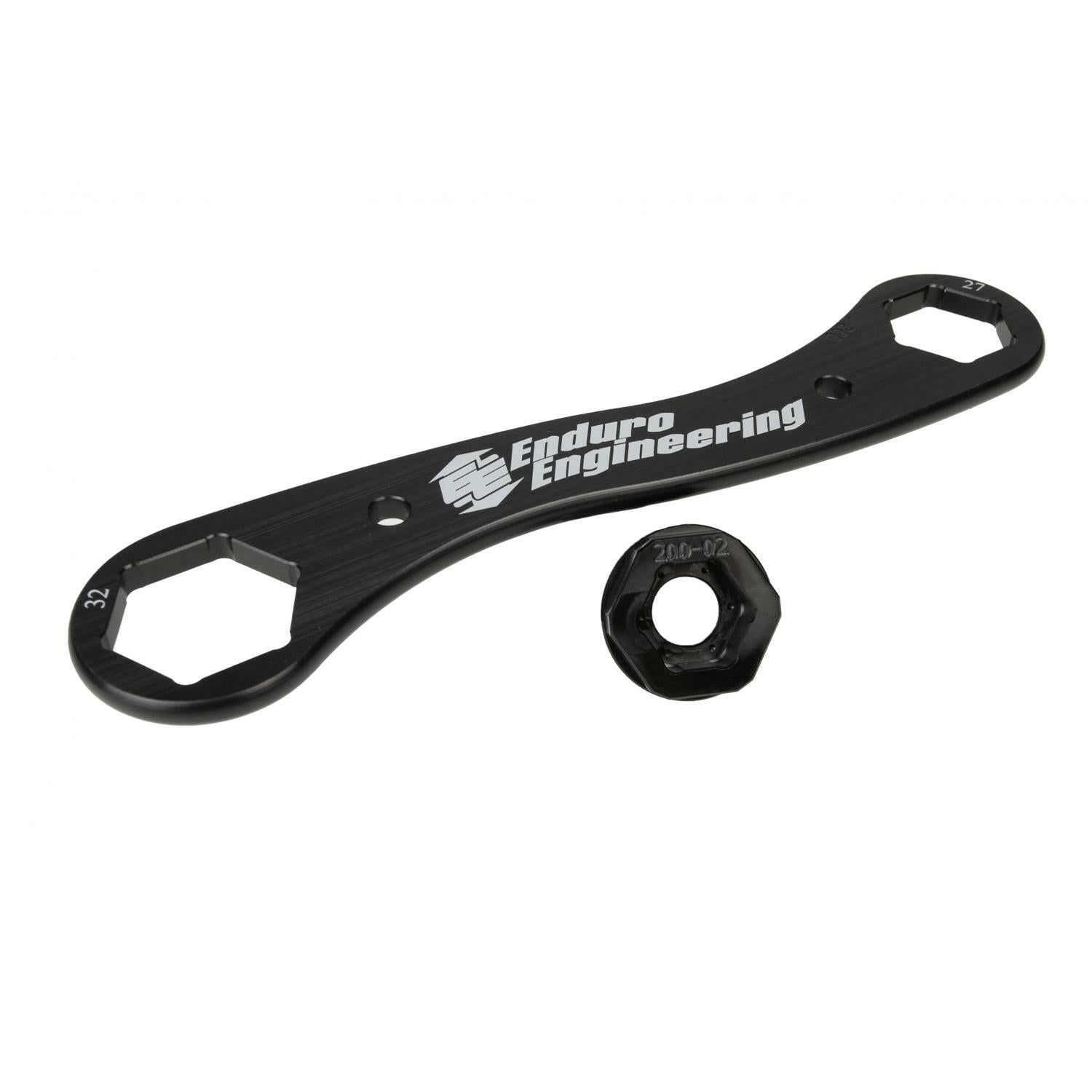 The Trail Multi Tool 17 27 32Mm by Enduro Engineering, a lightweight black billet aluminum wrench with hexagonal ends and a matching black nut, is shown on a white background.