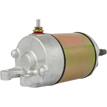 The Starter Motor by Parts Unlimited features a cylindrical metal body with silver ends, a gold-toned center, mounting brackets, and a threaded terminal. Built to OEM specs and equipped with durable copper bushings for reliability.