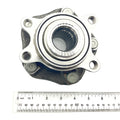 Silver metal unitized hub with circular bearing and five evenly spaced bolt holes, placed above a ruler for scale.