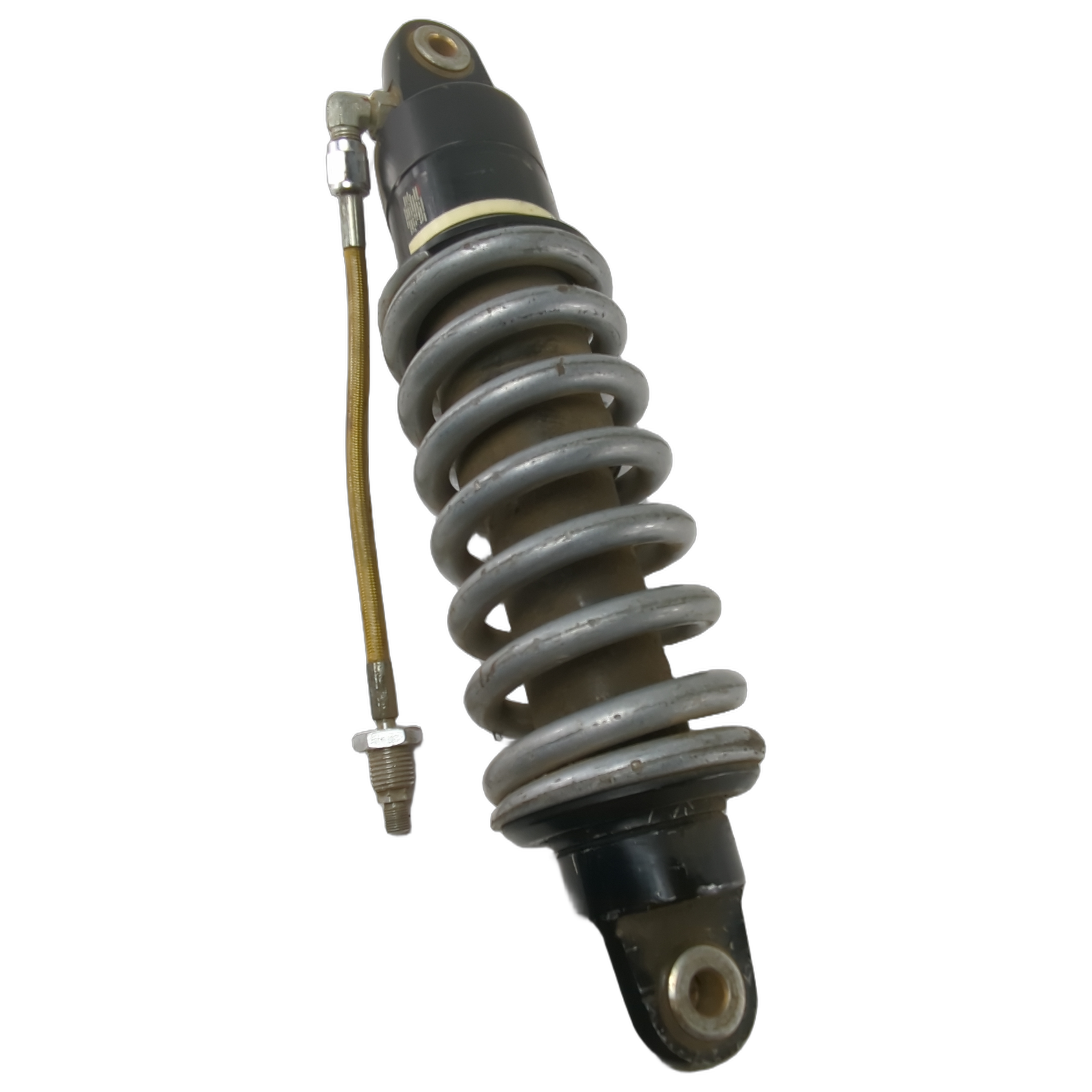 Black and silver touring motorcycle shock absorber with coil spring and attached hydraulic line.