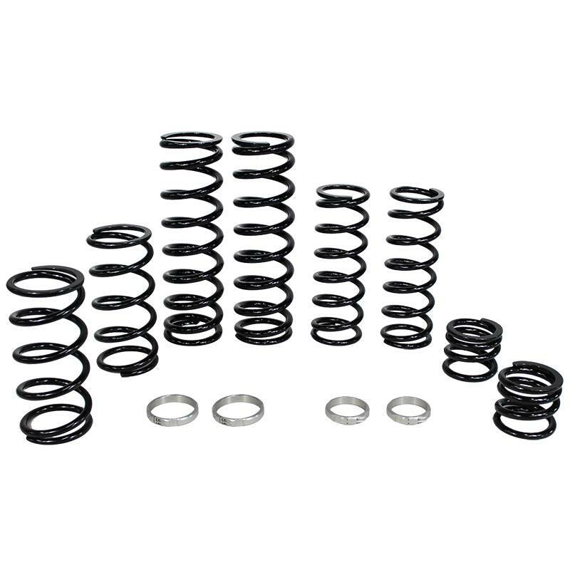 The Polaris Dual Rate Spring Kit by ZBroz features black metal coil springs of varying heights for increased bottoming resistance, arranged in a row with four silver metal rings in front, all displayed on a white background.