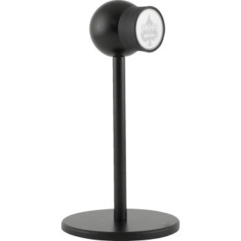The iOmini™ Stand iOmounts™ Mini Black by Klock Werks is a modern, black cylindrical tabletop stand with a round base, shown at an angle against a white background.