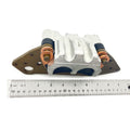 Silver metal right double brake caliper with copper brake line fittings on a brown mounting bracket next to a ruler.
