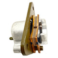 Silver metal rear brake caliper with copper brake pads and bronze mounting bracket.