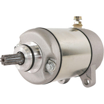 The Starter Motor by Parts Unlimited features a metallic cylindrical body, copper bushings, mounting brackets, a gear shaft at one end, and electrical terminals at the other, shown on a plain white background.