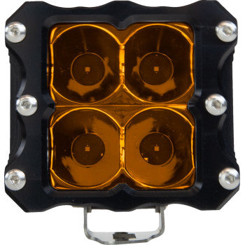 Close-up view of the Spotlight Amber by Heretic, a square LED off-road light with four circular amber CREE LEDs, black aircraft-grade aluminum frame, and visible corner screws.