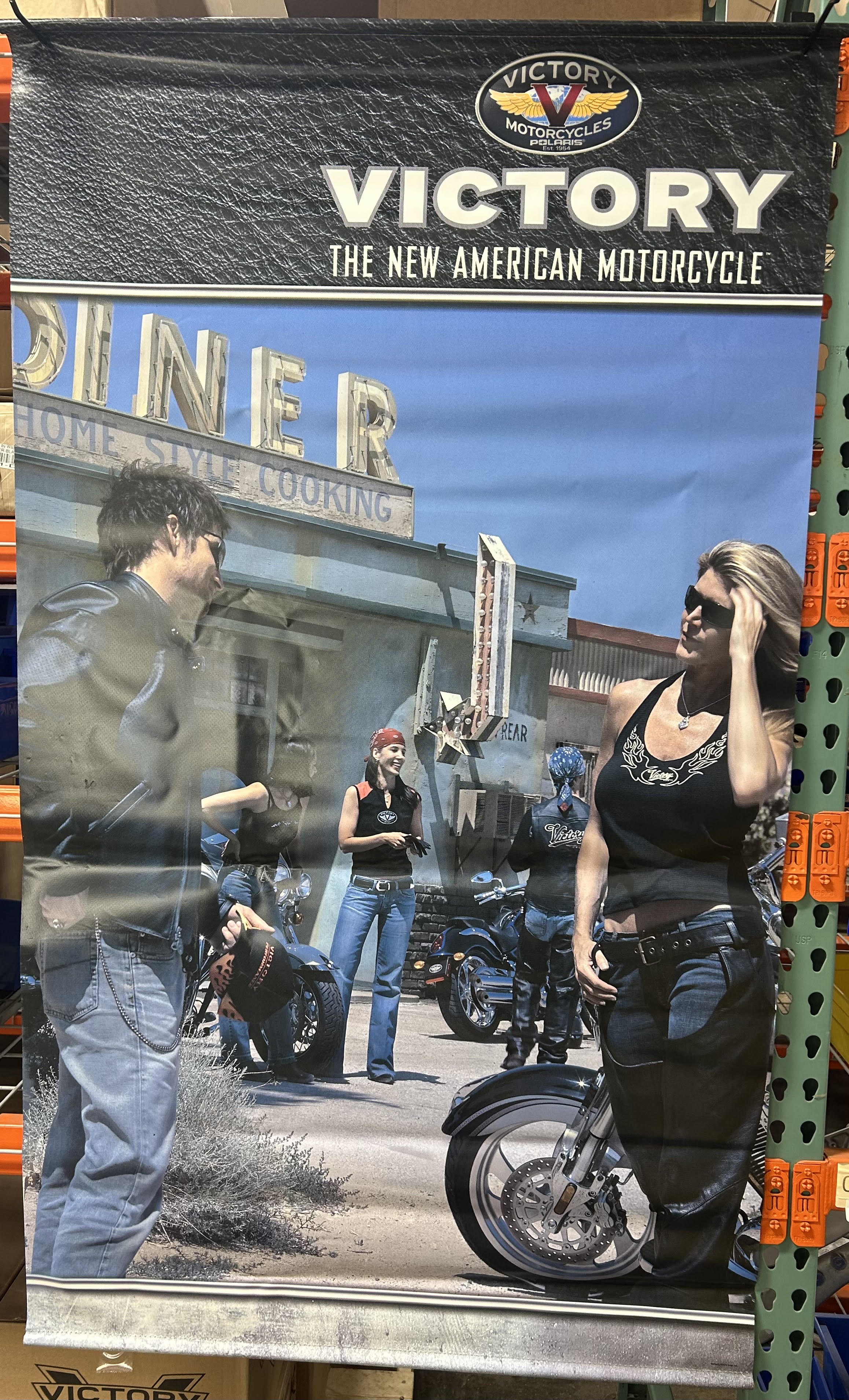 Victory motorcycle rally banner with a blue-and-black design, bold white lettering, and riders beside a motorcycle.