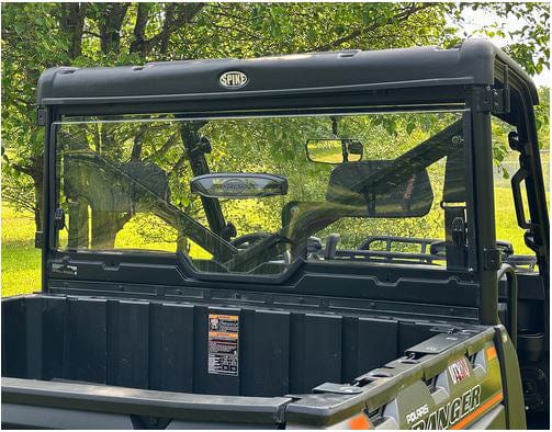A Polaris Ranger 1000 / XP 1000 (2013-2023) utility vehicle is parked outdoors, featuring a Spike vented hard coated rear windshield for safety, with the cargo bed visible against a backdrop of trees and green grass.