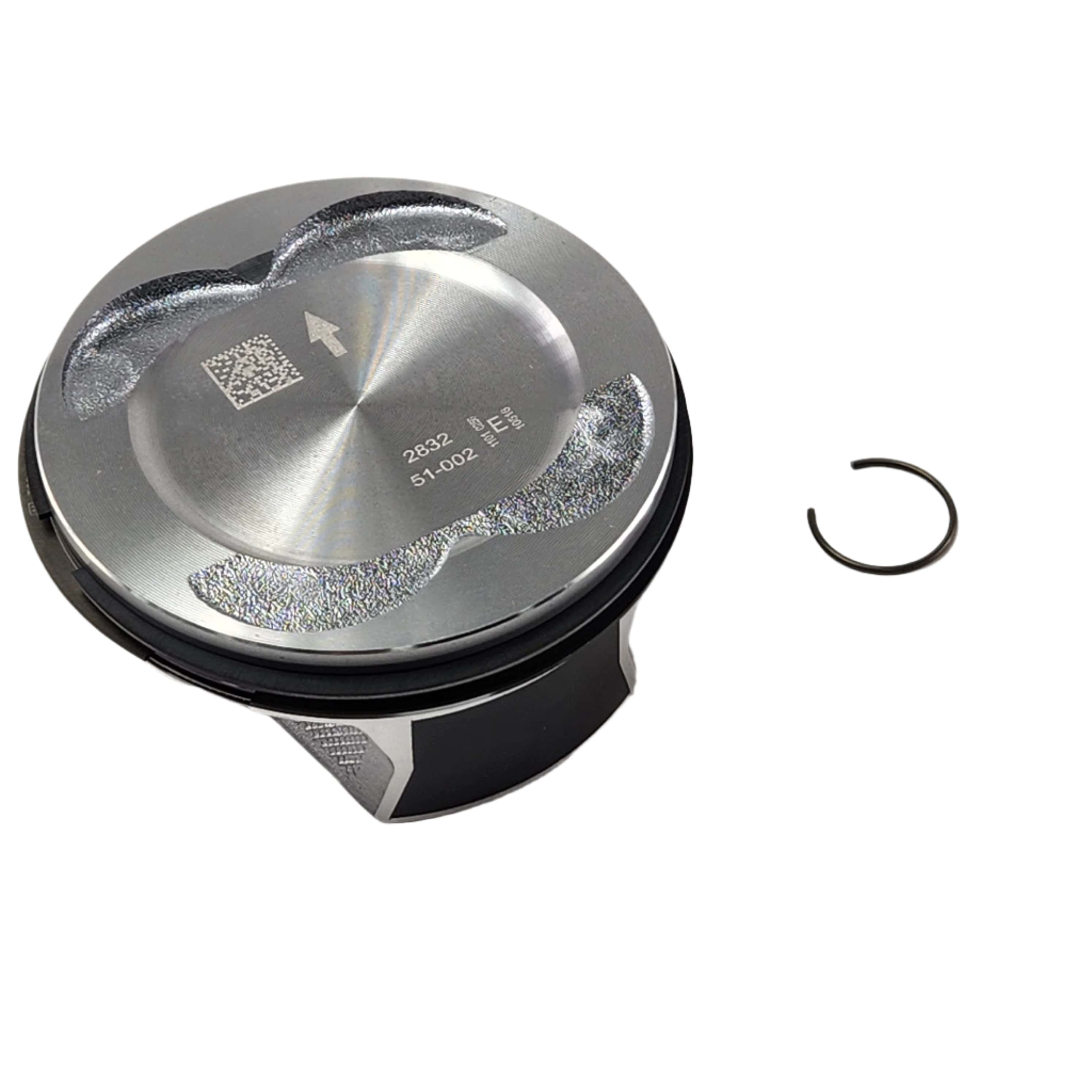 A shiny metal piston assembly with a flat top surface and a circular retaining clip on the right, set against a white background—Assembly, Piston [Incl. Rings, Pin, Ret. Rings] by Polaris, an essential OEM part for your Victory motorcycle.
