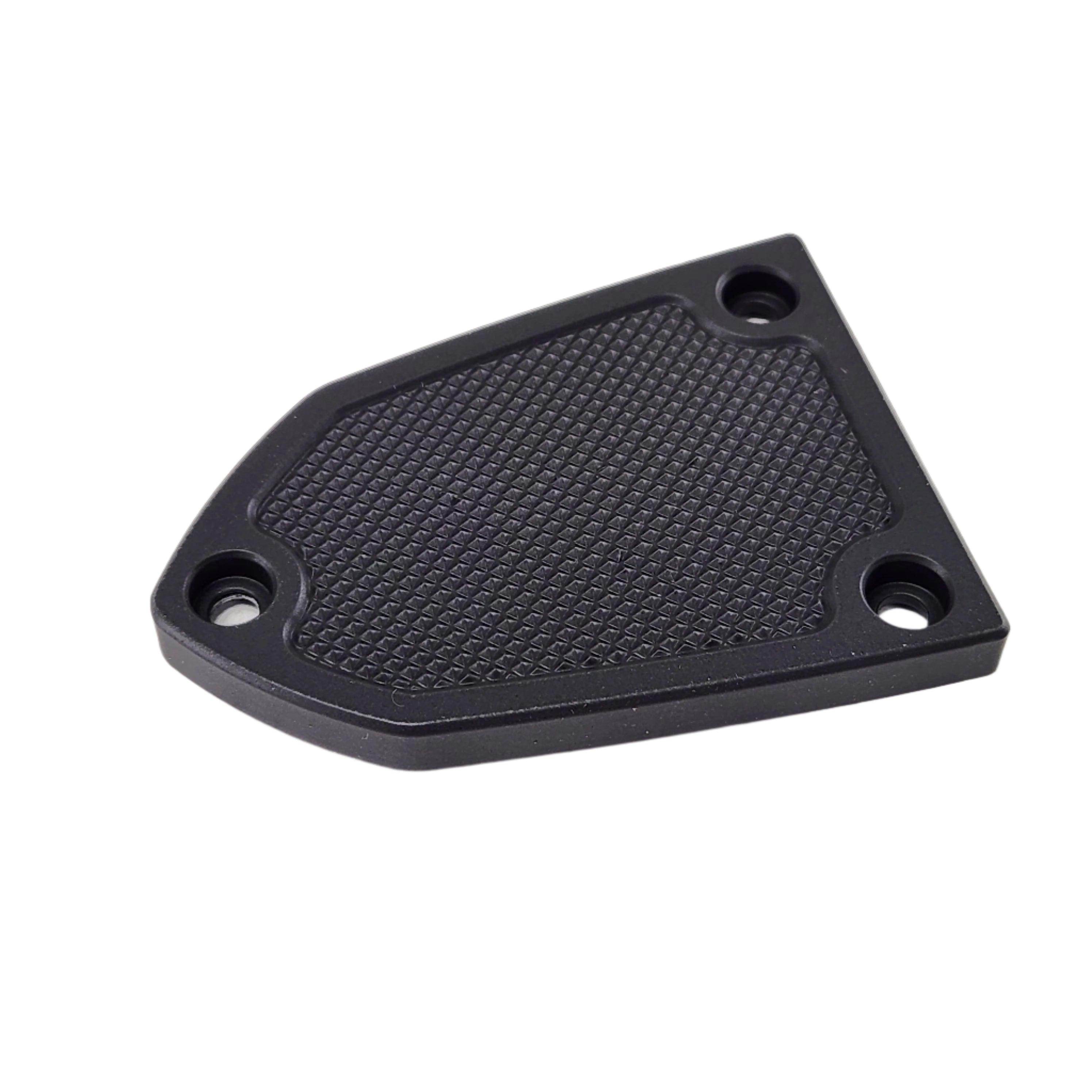 A black, textured, polygonal metal plate with three screw holes is shown on a white background as the Front Brake Master Cylinder Cover Knurled Black by Taylor Specialties, a potential accessory for Victory motorcycles.