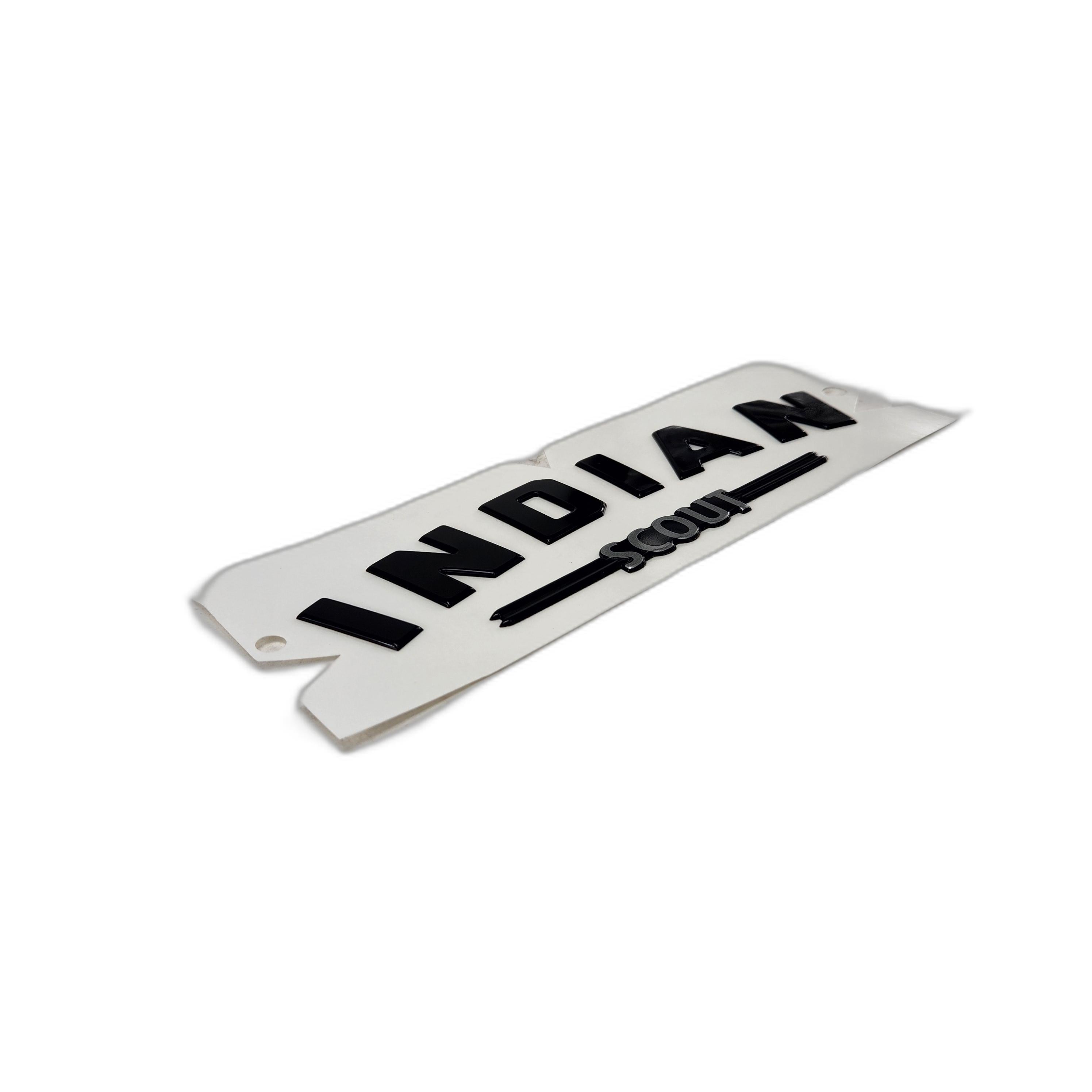A white metal plate with raised black text reads Badge Tank Block Black | [Black] by Polaris, likely a tank badge or emblem for Indian Motorcycle, photographed on a plain white background.