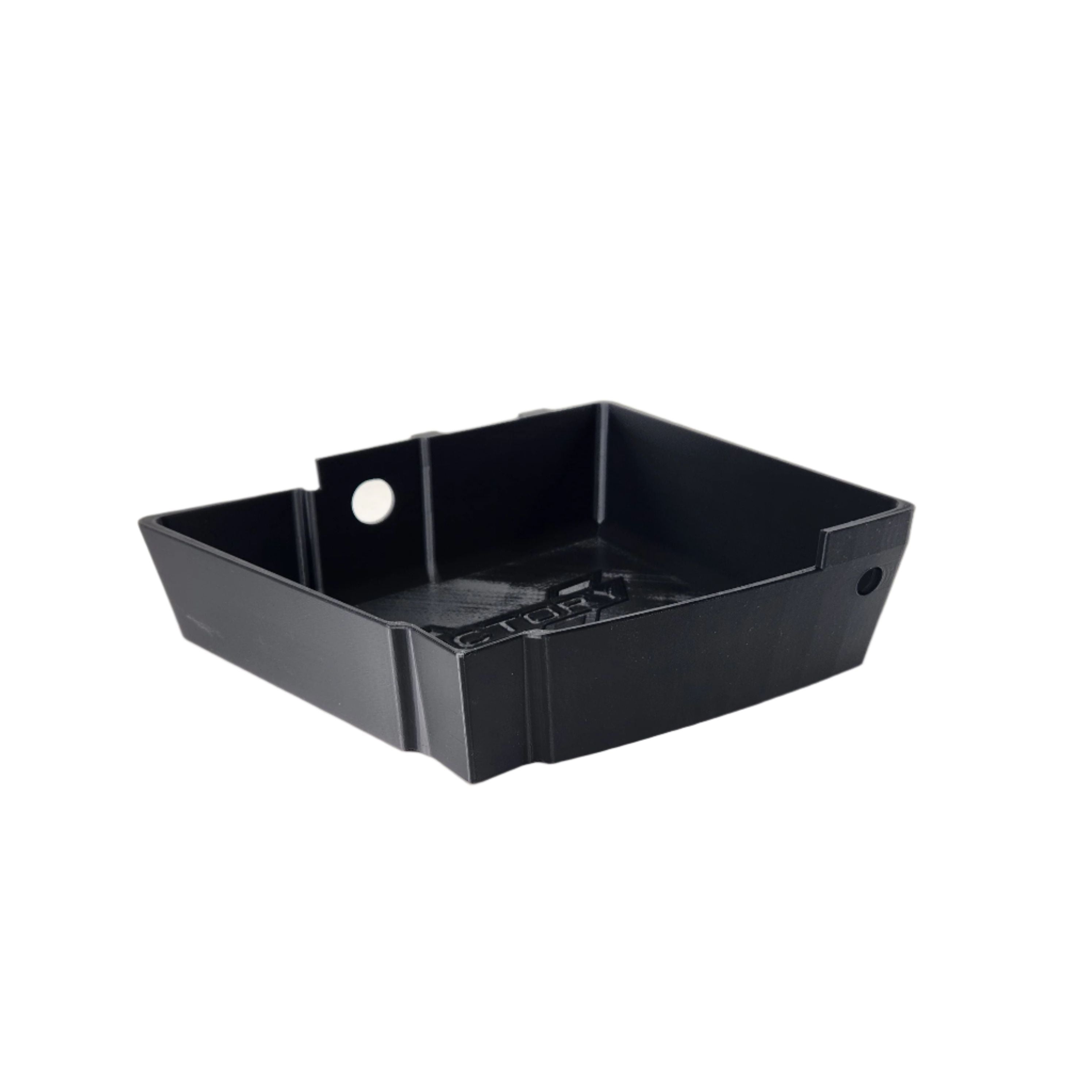 The Saddlebag Organizer Tray by Disruptive Misfit Solutions is a black, rectangular plastic tray with two oppositely placed holes and raised edges, ideal for motorcycle storage on a Victory Cross Country. Shown on a white background.