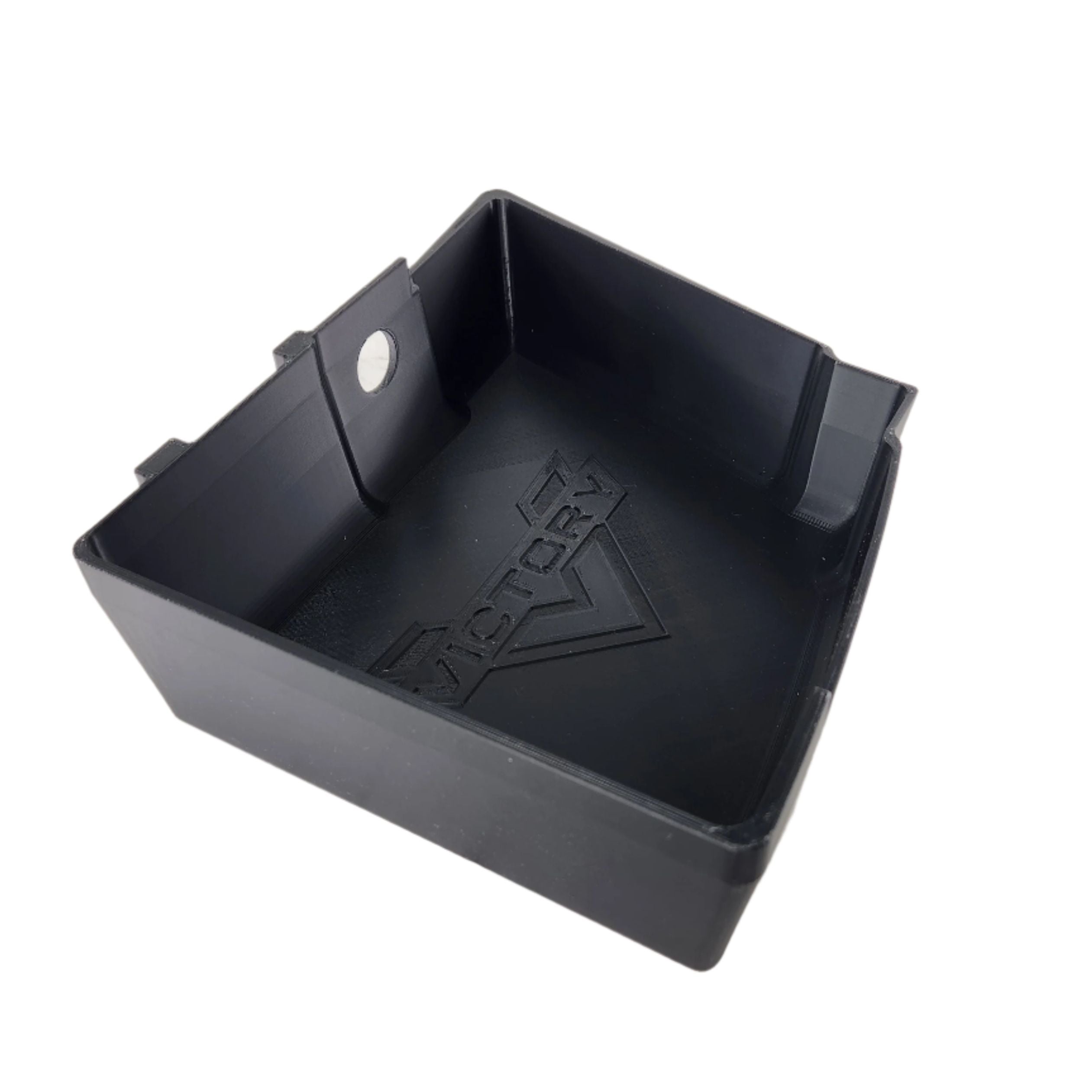 A black rectangular plastic Saddlebag Organizer Tray by Disruptive Misfit Solutions, featuring raised edges and VICTORY with a V logo embossed inside, ideal for Victory Cross Country motorcycle storage, on a light surface.