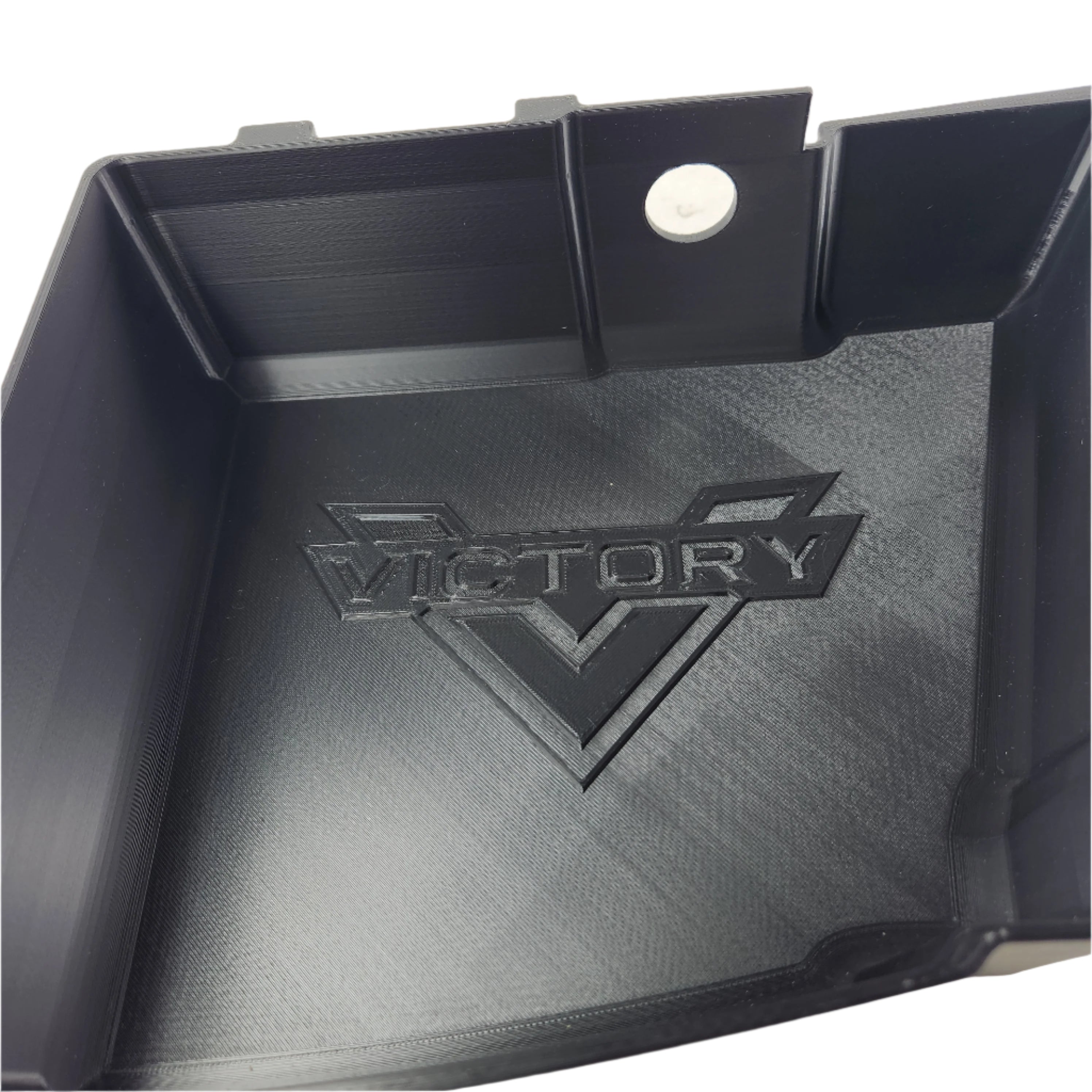 The Saddlebag Organizer Tray by Disruptive Misfit Solutions is a black plastic tray for Victory Cross Country motorcycles, featuring VICTORY embossed over a stylized V, a smooth finish, and a round hole near one corner for easy storage.