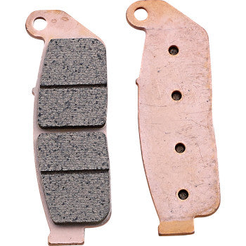 Two Sintered Brake Pads by Drag Specialties are shown: one features a textured, dark gray two-segment friction surface, while the other displays a smooth copper-colored backing plate with three holes and a mounting tab.