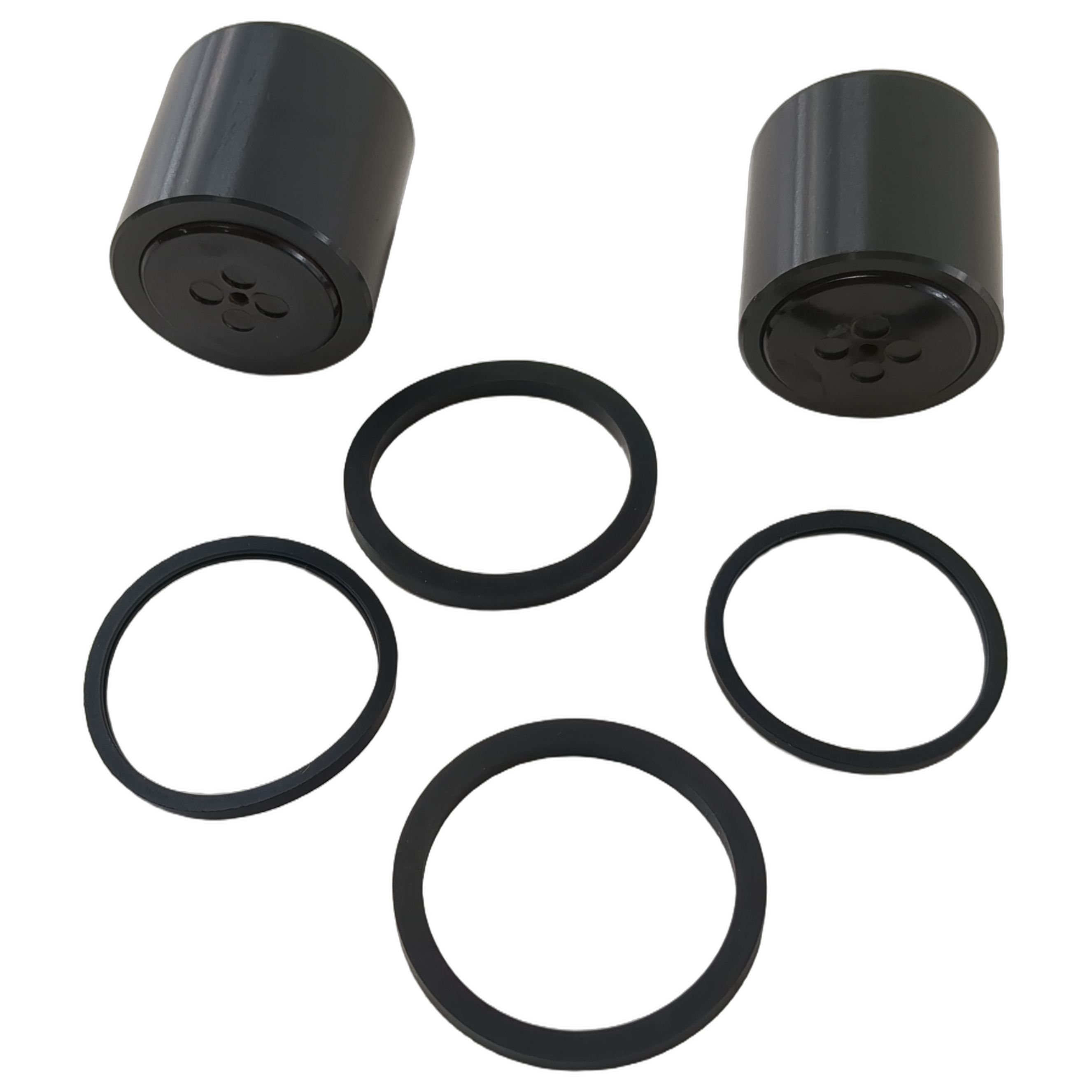 Two black cylindrical front caliper pistons with five black rubber seals of varying sizes arranged below them.