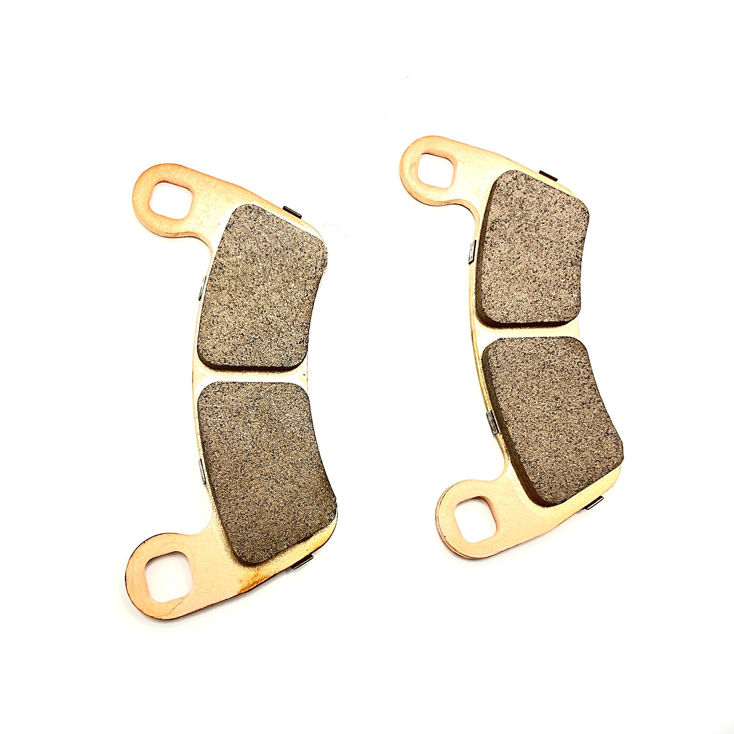Pair of gold metal-framed brake pads with textured friction surfaces, mounting holes on each end.