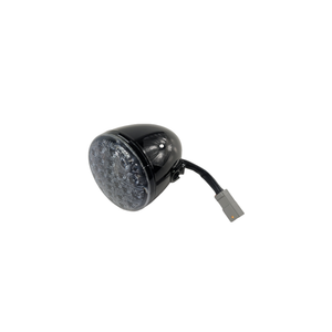 Black rounded rear motorcycle turn signal with multiple LED lights and attached wiring plug.