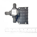 Black plastic 3-way valve with grid-pattern mounting plate and three hose connectors next to ruler.