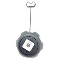 Black plastic gas tank cap with tether wire and rectangular white barcode sticker on top.