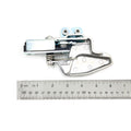 Silver metal door latch with spring mechanism and mounting holes shown next to a ruler for size reference.