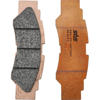 Set of four brake pads with dark gray friction surfaces and copper-colored backing plates, rectangular with angled edges and