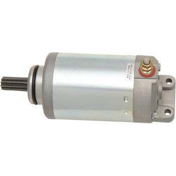 Silver cylindrical starter motor with black gear on one end and electrical terminals on the other, mounted on a gray metal.