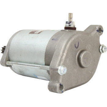 The Starter Motor by Parts Unlimited features a metallic cylindrical body, copper bushings, two mounting holes, and a top power terminal—engineered for reliable engine starts in vehicles or machinery.