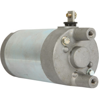 The Starter Motor by Parts Unlimited is a cylindrical, metallic unit with a silver body, gray end cap with bolts, threaded ports, and top electrical connection. Built for corrosion protection and meets OEM specifications.