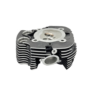 Black front machined motorcycle head cylinder with silver circular metal plate and cooling fins.