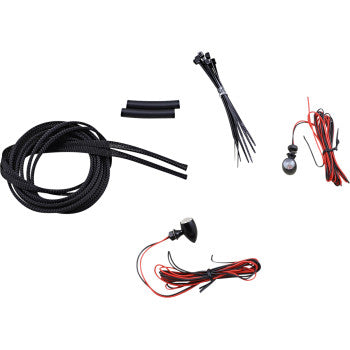 Small black micro turn signals with red lenses, wiring harness, zip ties, and connector sleeves for motorcycles.