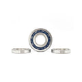 Set of three silver metal pinion bearings with one bearing showing blue inner seals on white background.