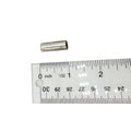 Small metallic cylindrical pin next to a clear ruler showing about 0.5 inch length.