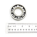 Steel ball bearing with visible metal balls inside circular frame next to white ruler showing size.