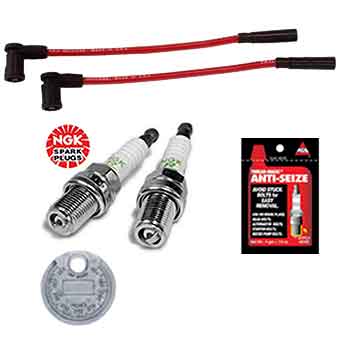 The Tune Up Kit for Victory Motorcycles 2002-2007 by Witchdoctors includes two red ignition wires, two spark plugs, anti-seize lubricant, an NGK logo, and a silver keychain to help restore optimal motorcycle performance.