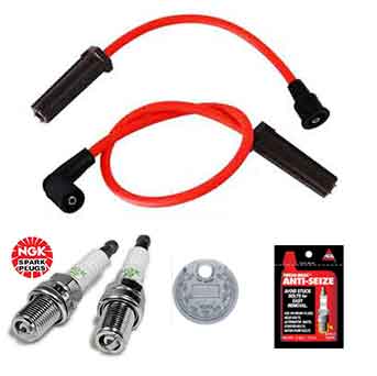 The Tune Up Kit for Victory Motorcycles 2008-2017 by Witchdoctors includes red spark plug wires, two NGK spark plugs, a round metal washer, and an anti-seize packet—perfect for V-Twin engine maintenance.