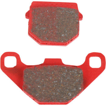 Red-framed organic brake pads with textured friction surfaces, shaped for exact offroad fitment.