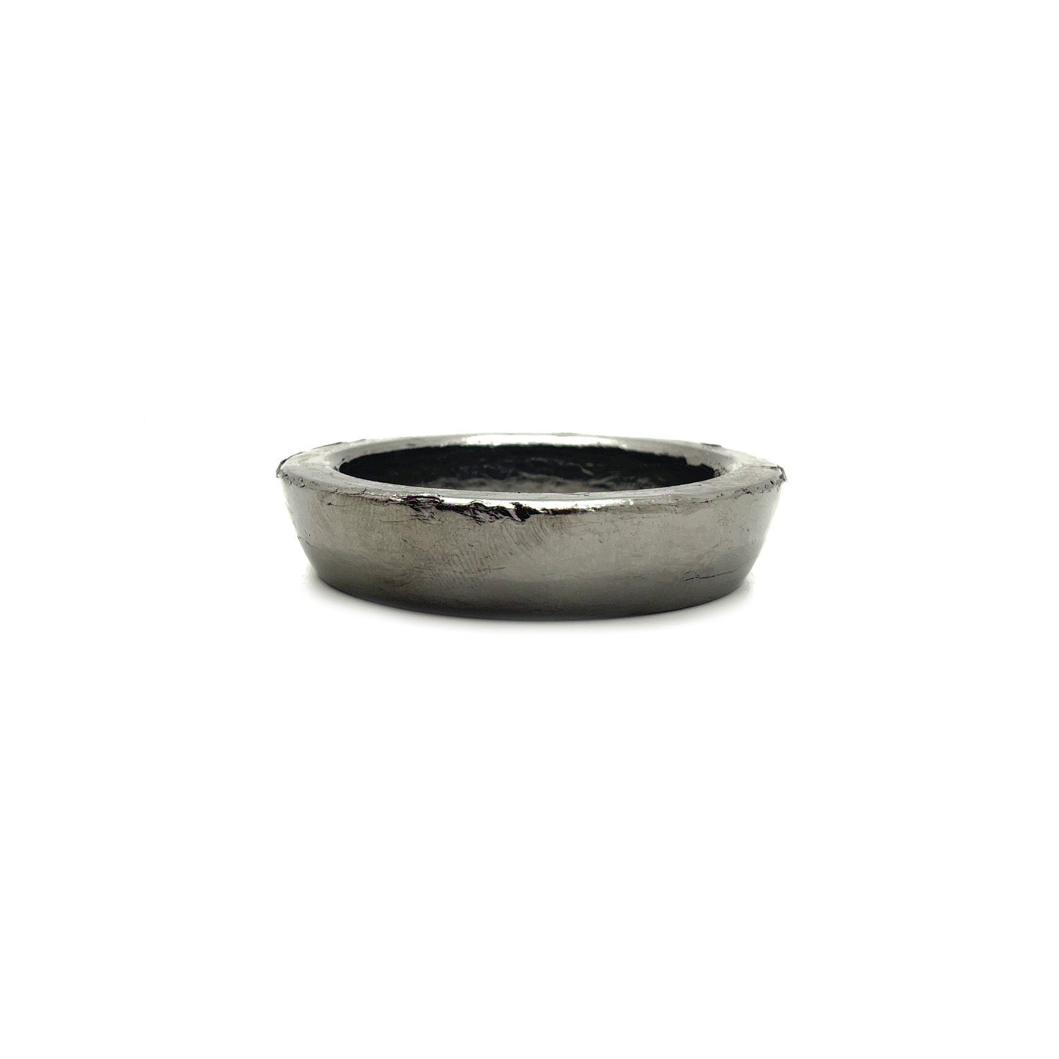 Metal exhaust socket gasket with a slightly raised outer edge and textured inner seal.